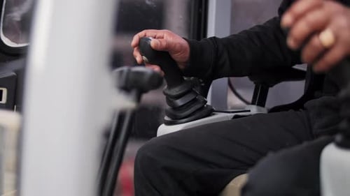 Operator Hand Controlling Joystick Inside Industrial Vehicle Cabin