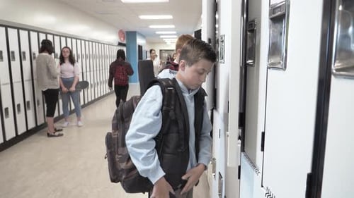Teenagers in School Hallway near Lockers Using Smartphones