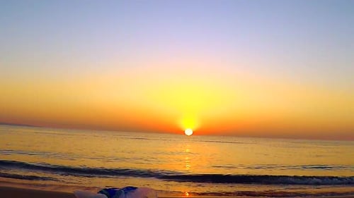 Golden Sunrise Over Calm Ocean Waves on Beach