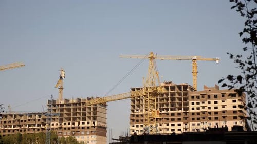 Construction Site Background Hoisting Cranes and New Multistorey Buildings