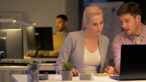 Business, Success and Deadline Concept - Happy Team with Laptop Computer Working