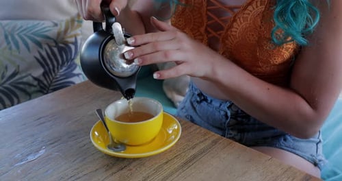 Woman with Blue Hair Pours and Drinks Tea