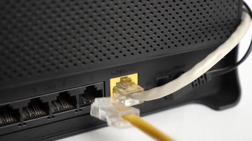 Ethernet Cable being plugged into Wireless Router