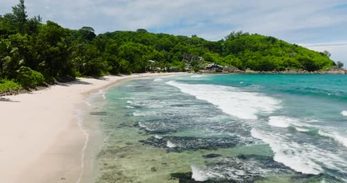 Waves Crashing Against Coral Reefs on a Sandy Beach Seychelles Mahe