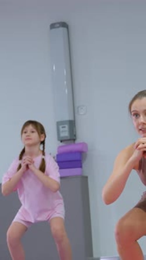 Young Woman and Girl Exercising Together Indoors