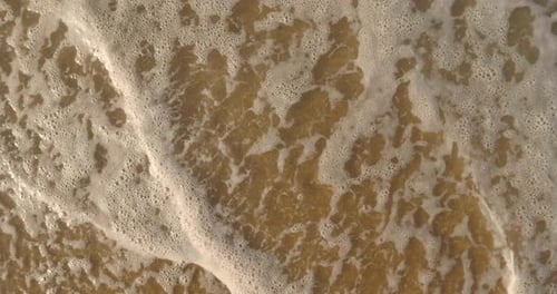 Waves on brown sand, washed off by wave background. Concept: rest, the sea, the beach, the coast,
