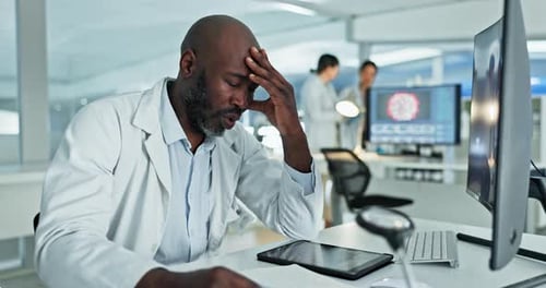 Researcher with Hand on Head in Lab