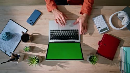 Professional Hands Working Chroma Key Laptop in Office Environment Top View