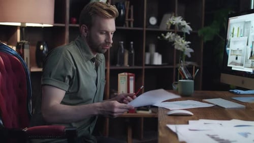 Creative Designer Reading Business Project in Home Office. Young Interior Designer Looking