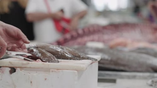 Zubereitung von frischem Fisch auf dem belebten Markt in den frühen Morgenstunden