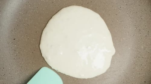 I flip the pancake in the pan with a silicone spatula. Top view