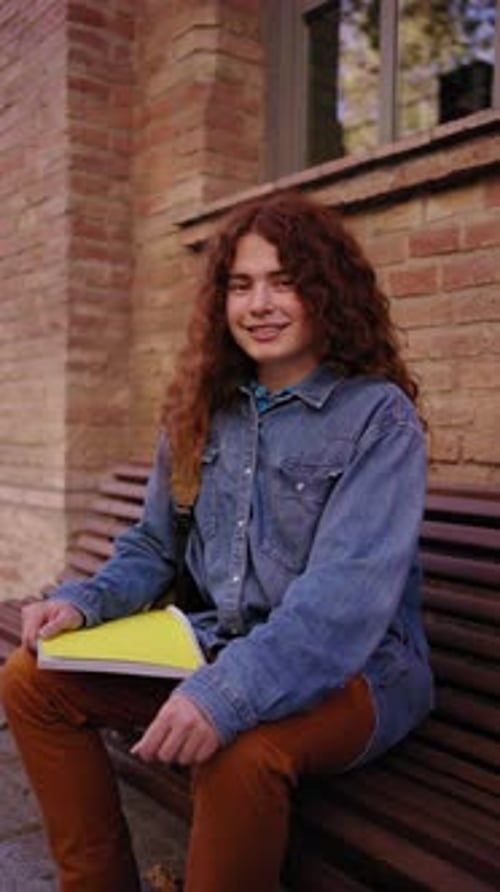 Portrait of Young Happy Caucasian Red Head Student Outside the University Building Looking at Camera