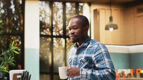 Man Enjoying Morning Coffee in a Bright Kitchen