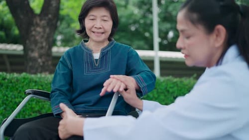 Woman in Wheelchair with Medical Professional in Park