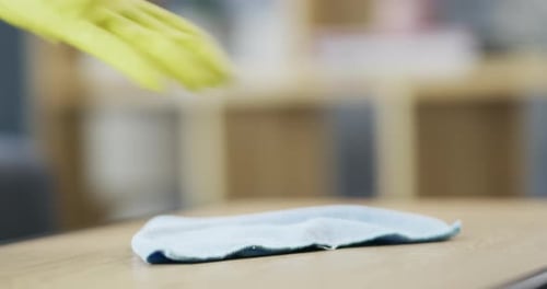 Hand in Glove Wipes Table Surface with Cloth