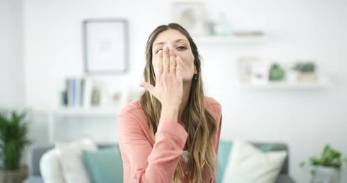 Smiling Woman Blows a Kiss in Bright Home