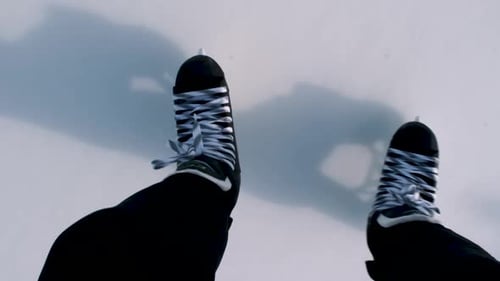 Slow-motion point of view from above of ice skates on ice