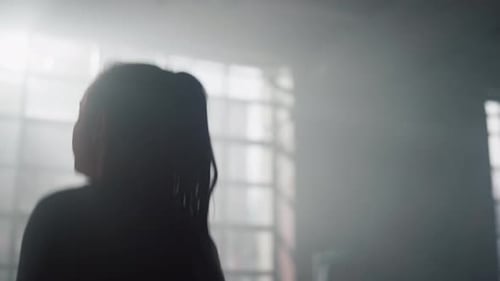 Energetic sportswoman jumps squats in modern gym during fitness training session