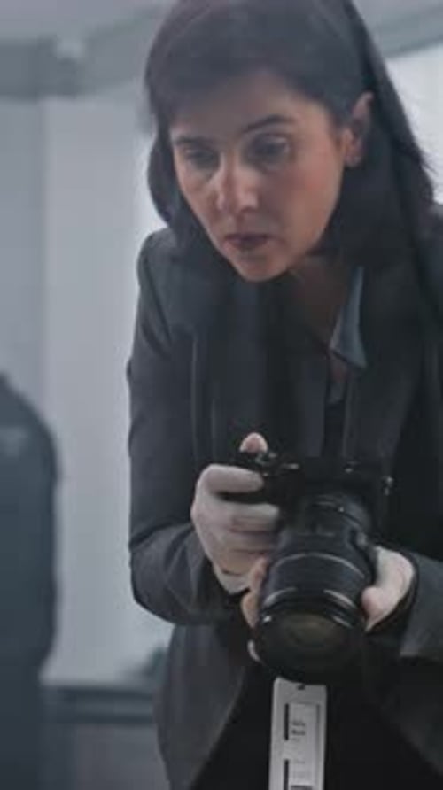 Woman with Camera and Gloves Inspecting Evidence