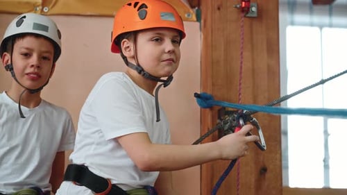 A Happy 10Yearold Boy Pulls a Winch in a Rope Park to Pass an Obstacle Course
