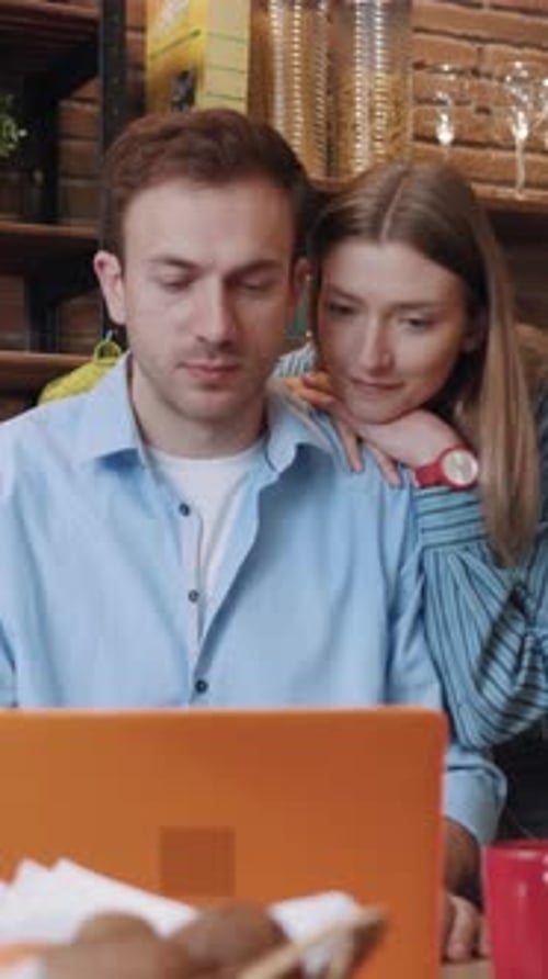 Young Couple Looking at Laptop Indoors