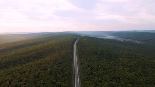 Aerial View of Autumn Woods and the Highway That Crosses the Forest