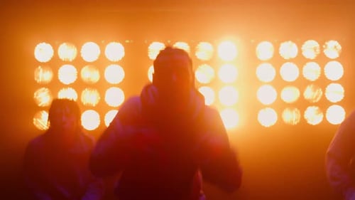 Men dancing in front of illuminated lights