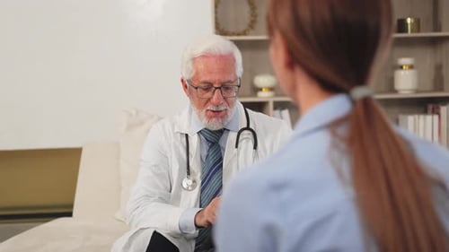 Senior Man Doctor Examining Young Woman in Doctor Office Clinic or at Home Girl Patient and Doctor
