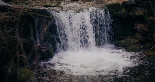 Water Flows Over Waterfall into Natural Pool