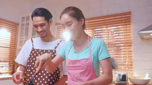 Smiling Couple Cooking Together in a Modern Kitchen