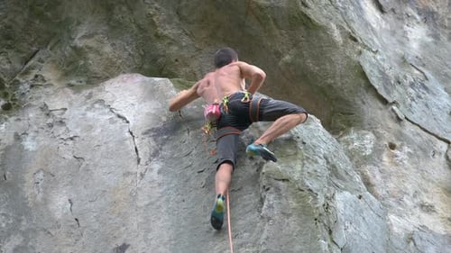 Young Man Climbing Steep Wall of Rocky Mountain Male Climber Overcomes Challenging Route Engaging in