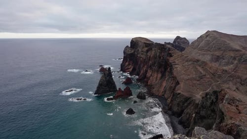 Dramatic cliffs and ocean waves crash against the rugged coastline of Ponta de São Lourenço in Madei
