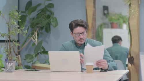 Man Works at Laptop in Office