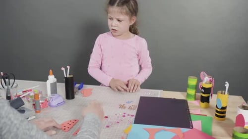Child and Adult Making Paper Crafts Together