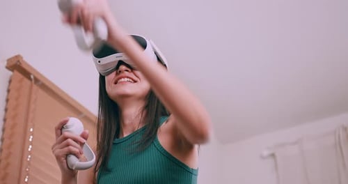 Woman Playing Virtual Reality Game with Headset and Controllers