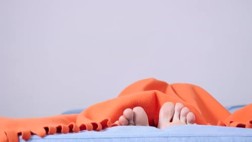 Pieds humains se déplaçant sous une couverture
