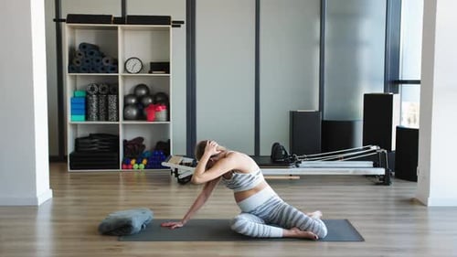 Expectant Fitness Trainer Demonstrates Safe Prenatal Back Stretch