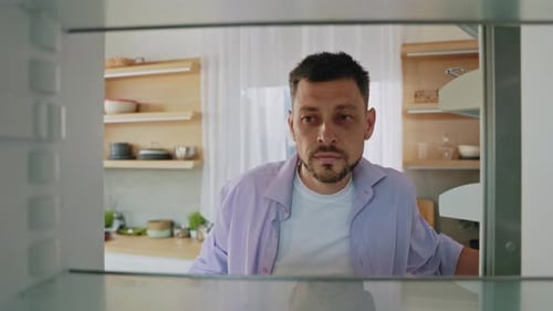 Man Opens Empty Fridge in the Kitchen