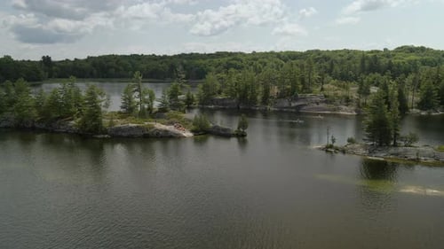 Numerous kayakers paddling on a lake with rocky islands.