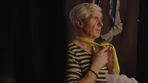 Man Tying Yellow Scarf Around His Neck