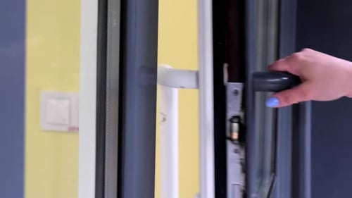 Woman Opening the Door of a Building