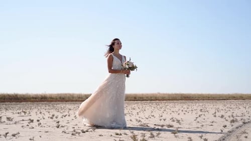 Pretty Young Bride Holding Delicate Bouquet at Desert Landscape Windy Weather Elegance Lady Waiting