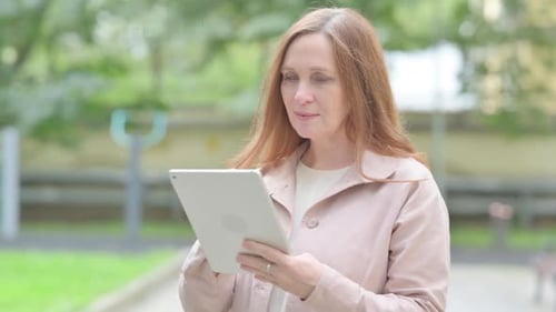Woman Using Tablet in Urban Green Park
