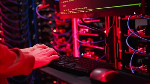 Close up of a man trying to fix an error on a computer in a server room