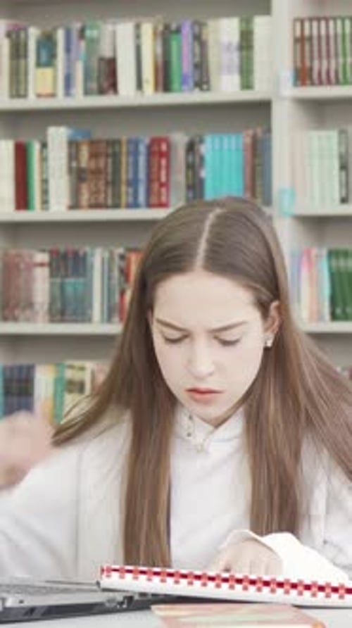 Teen Female Student Overwhelmed By Project Stress in a Library