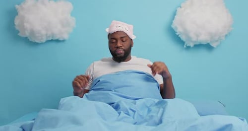 Man Waking Up Stretches in Bed