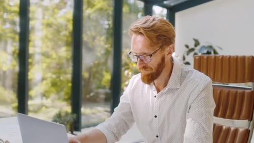 Focused Artist Working on New Project Using Laptop in Studio