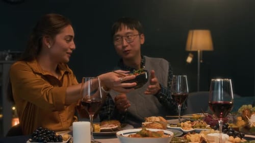 Friends Gathered Around Table Eating Food, Sharing Wine