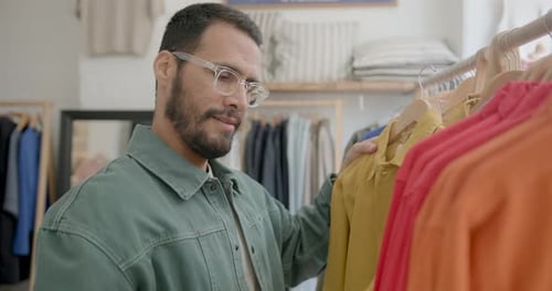 Stylish Man looking at price tag on a shirt in a clothing store