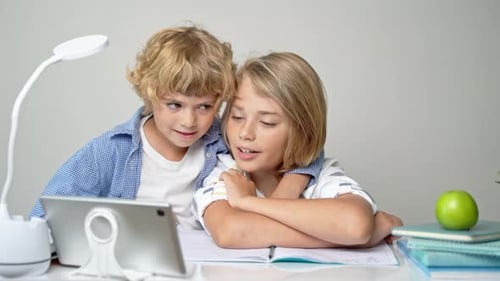 Middle Primary School Students Boy Girl Remotely Studying Writing Book Homework and Tablet at Class
